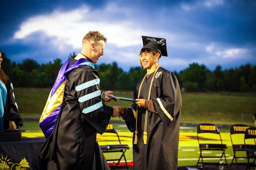 Students graduate on a football field